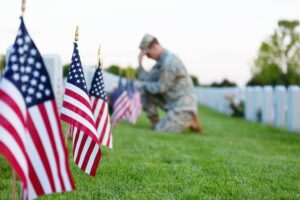 Soldier kneeling at grave-cm